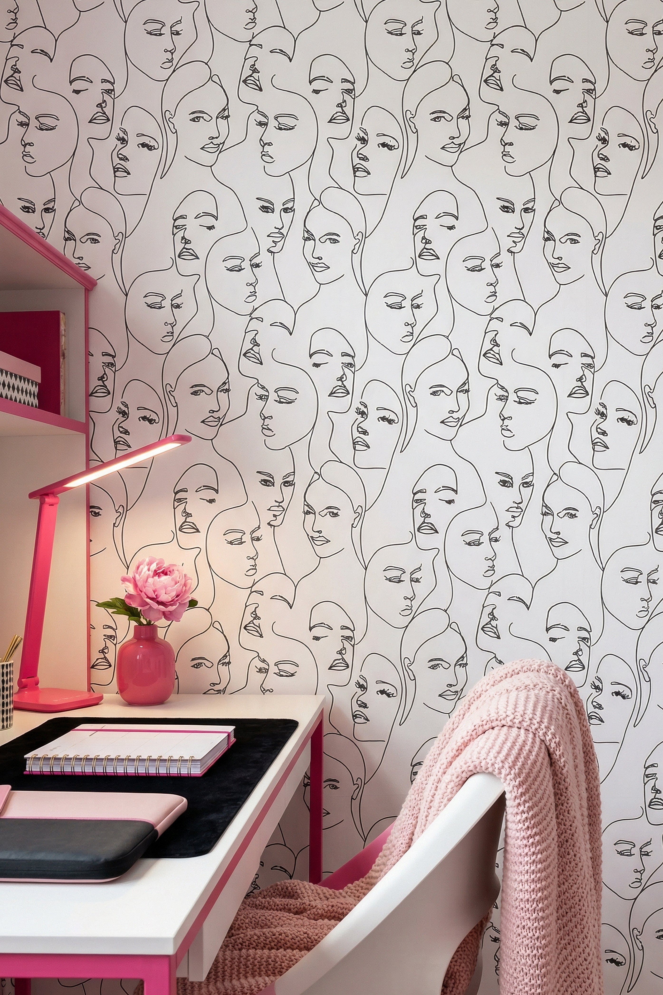Continuous black contour line drawings on white wallpaper in a home office.