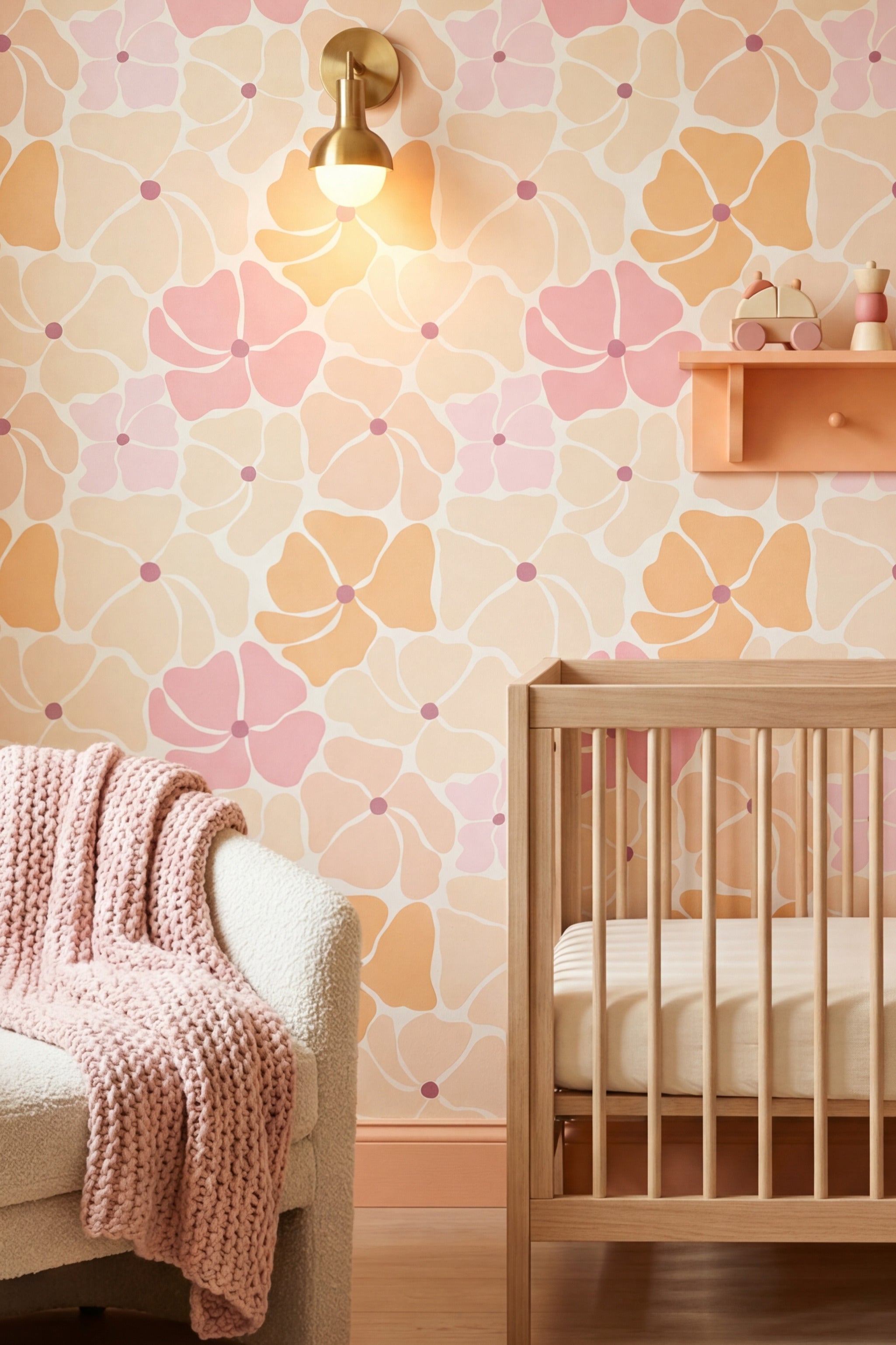 Pink and coral watercolor blooms on cream floral wallpaper in a nursery.