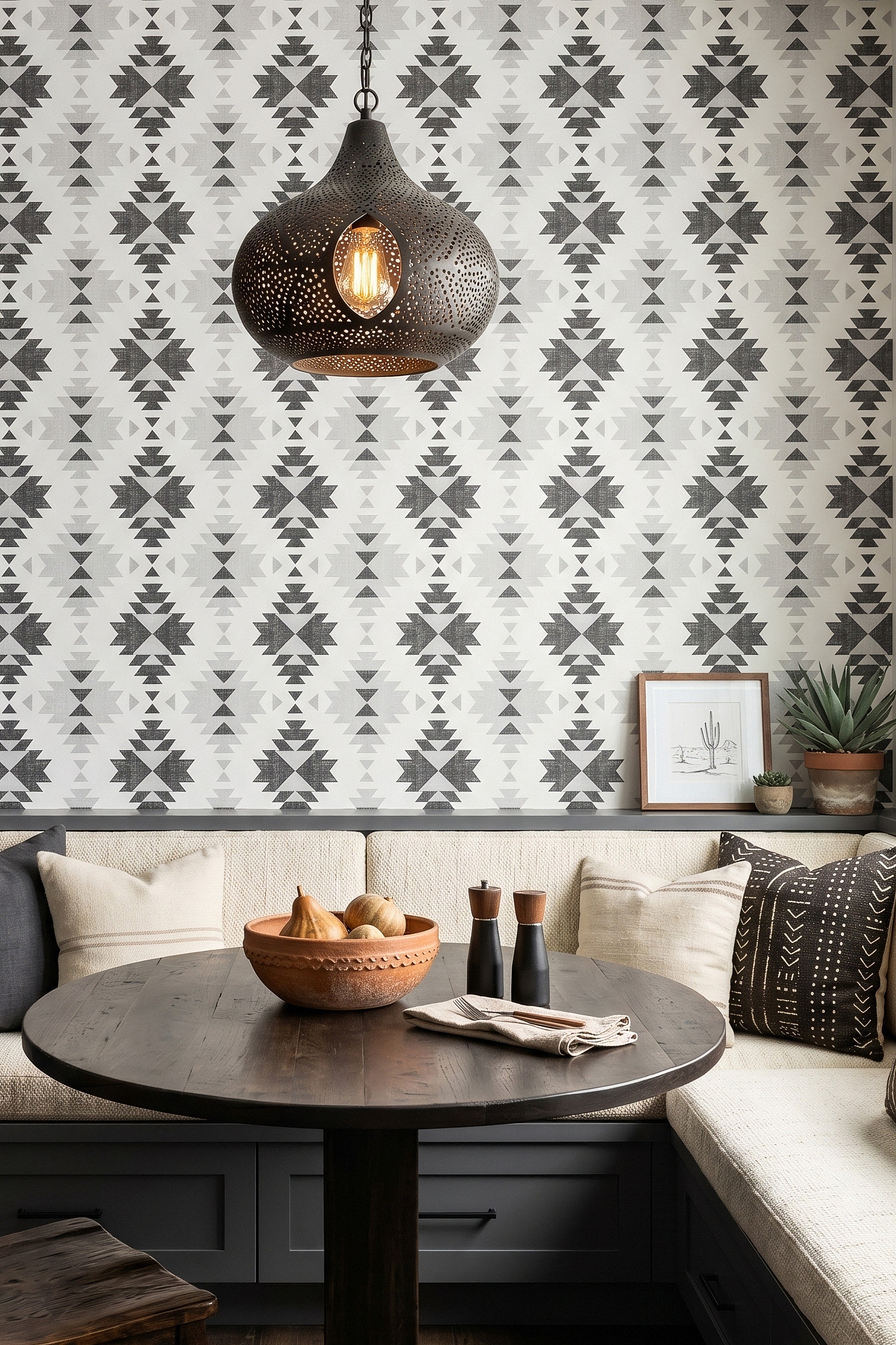 Bold black Southwest geometric motifs on white wallpaper in a cozy nook.