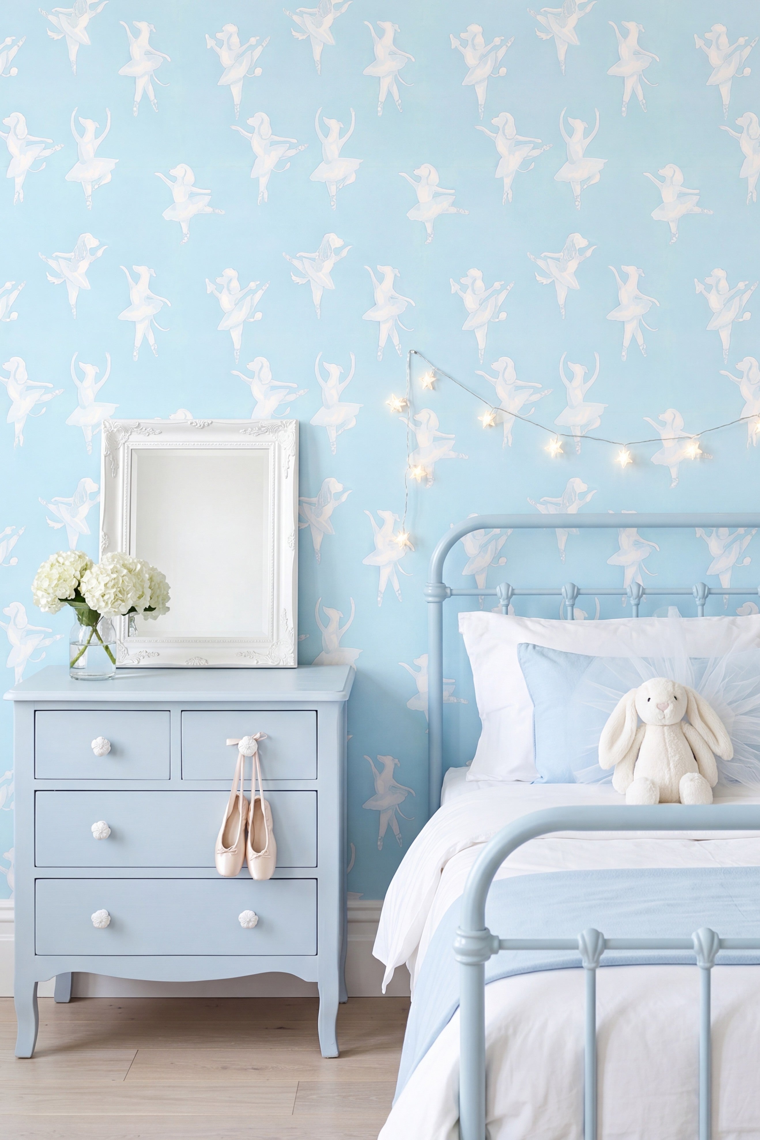 White ballerina puppies on a soft aqua blue wallpaper in a kids' room.