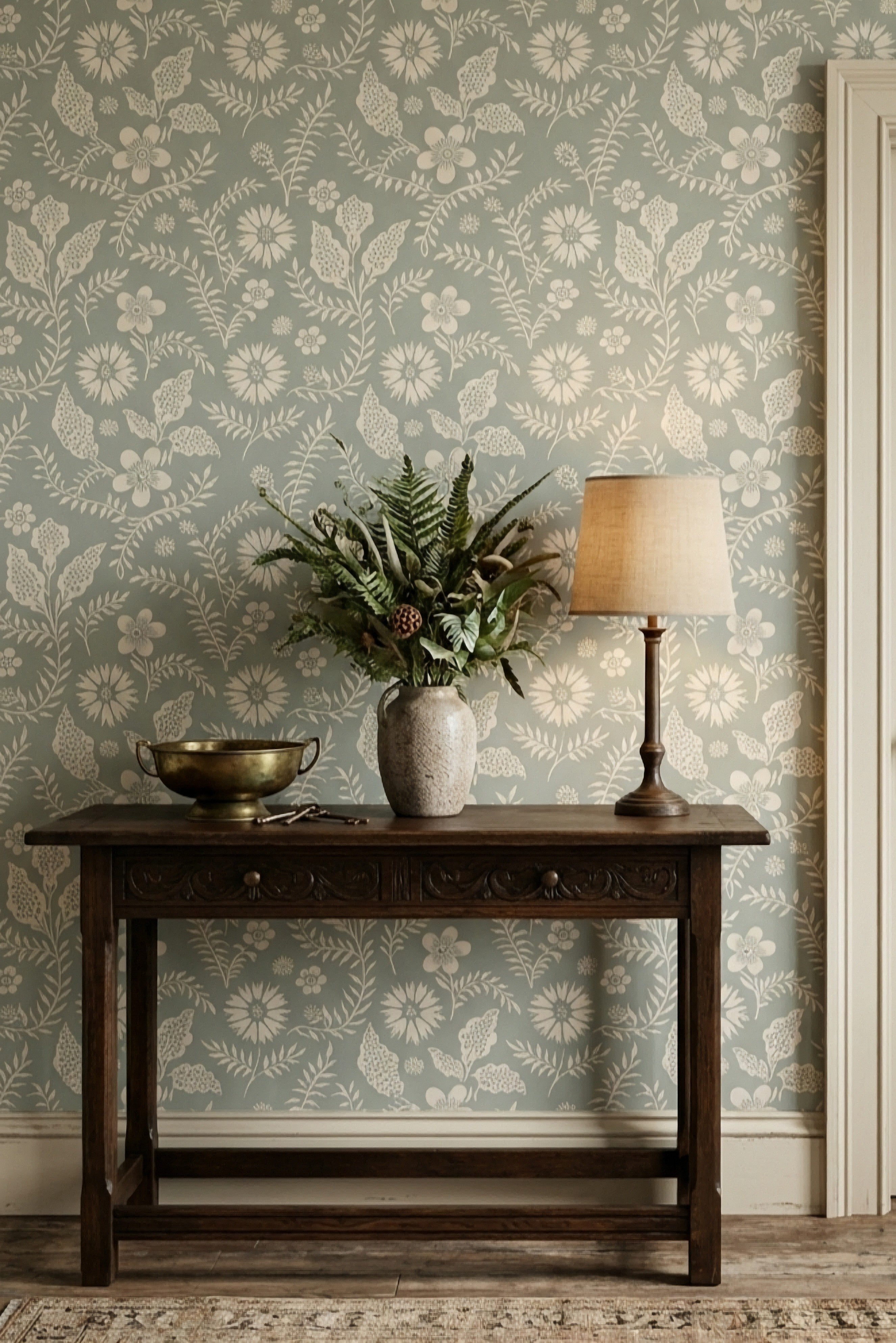 Soft blue-green block-print botanicals on warm cream wallpaper in an entryway.