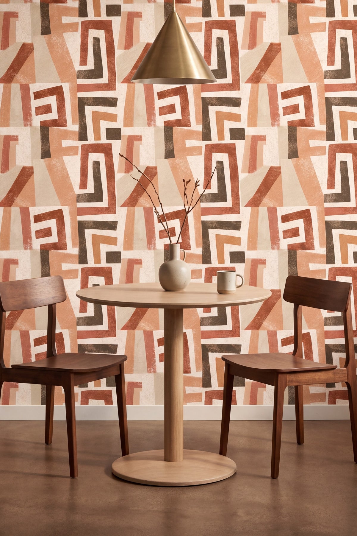 Large angular rust and terracotta cut shapes on cream wallpaper in a kitchen.