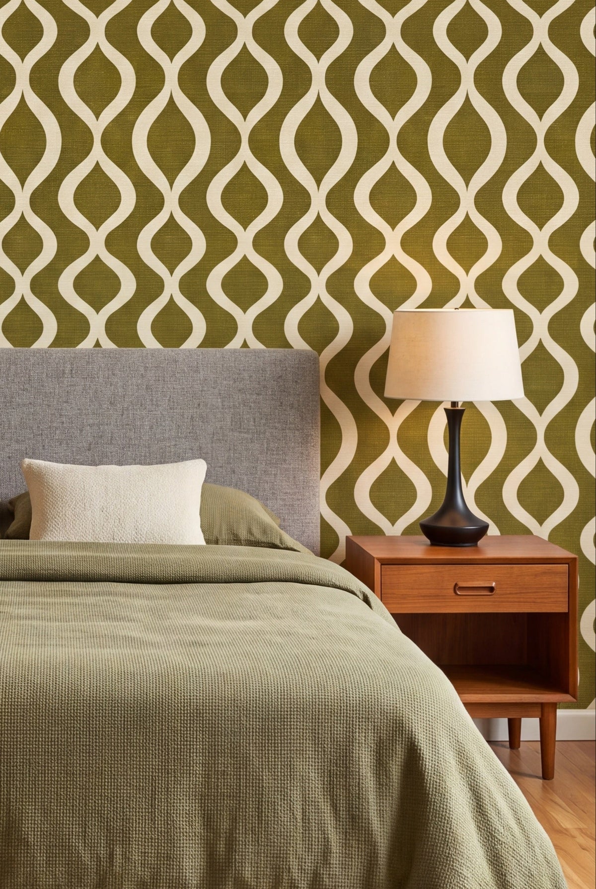 Olive Pendulum wallpaper in cream on olive linen on a bedroom wall.