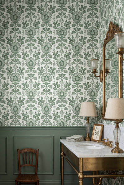 Layered green scrolling vines and acanthus on Morris-style wallpaper in a powder room.