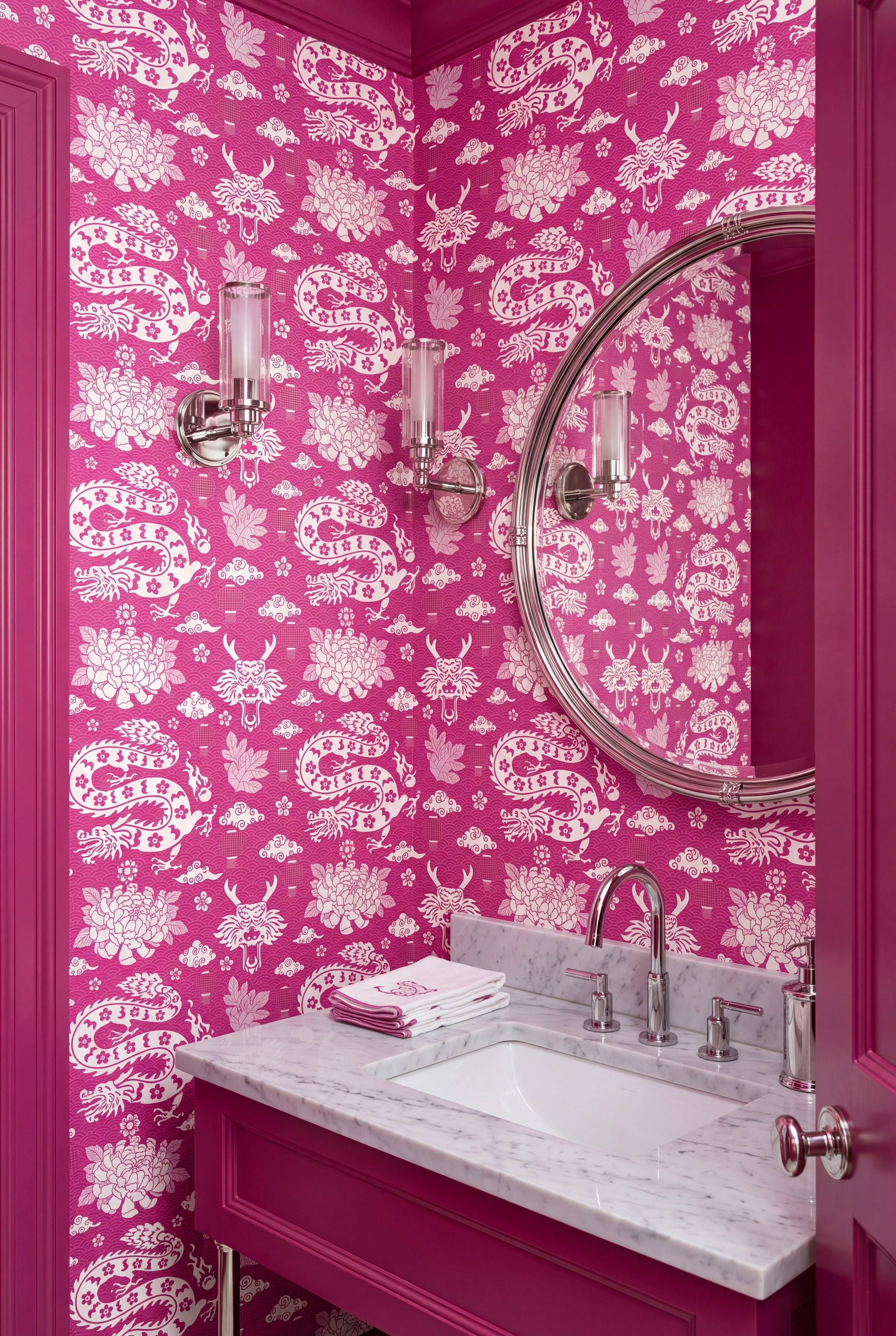 White dragon coiling over bright pink wallpaper in a powder room.