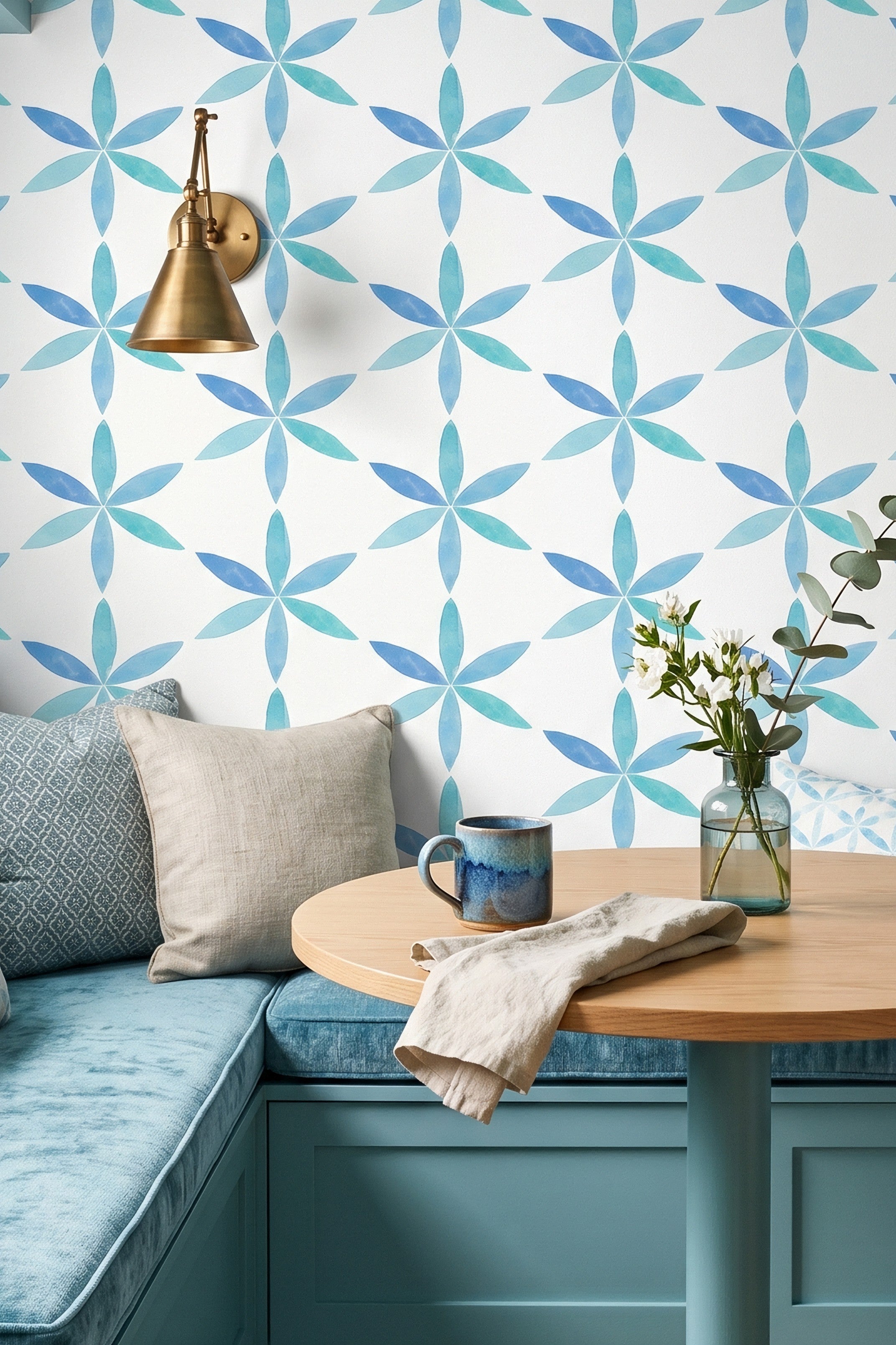 Ocean blue watercolor starbursts on white wallpaper in a cozy nook.