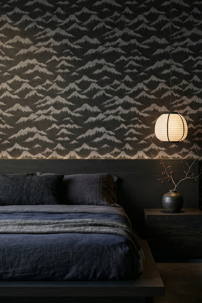 Gray misty mountain peaks on charcoal wallpaper in a bedroom.