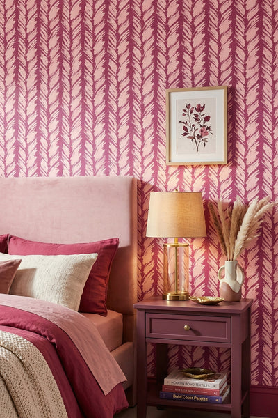 Soft pink strokes on a deep magenta striped wallpaper in a bedroom.
