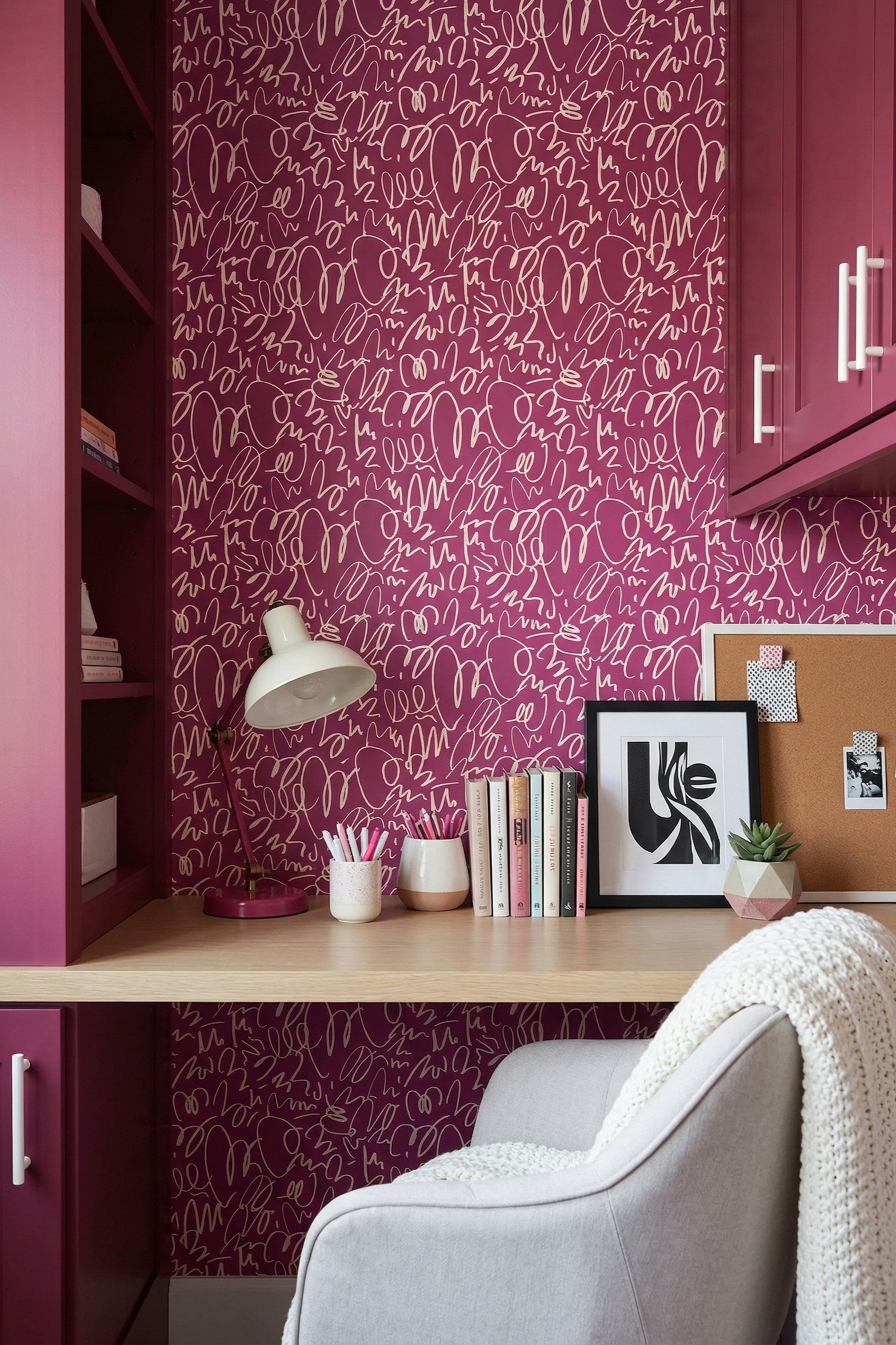 Light pink doodles roaming a deep magenta wallpaper in a home office.