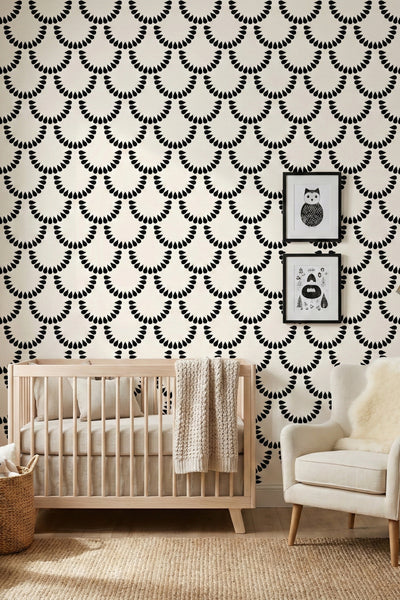 Bold black teardrop scallops on a soft ivory wallpaper in a nursery.