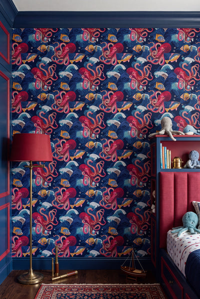 Navy and coral octopus and fish on an underwater wallpaper in a kids' room.