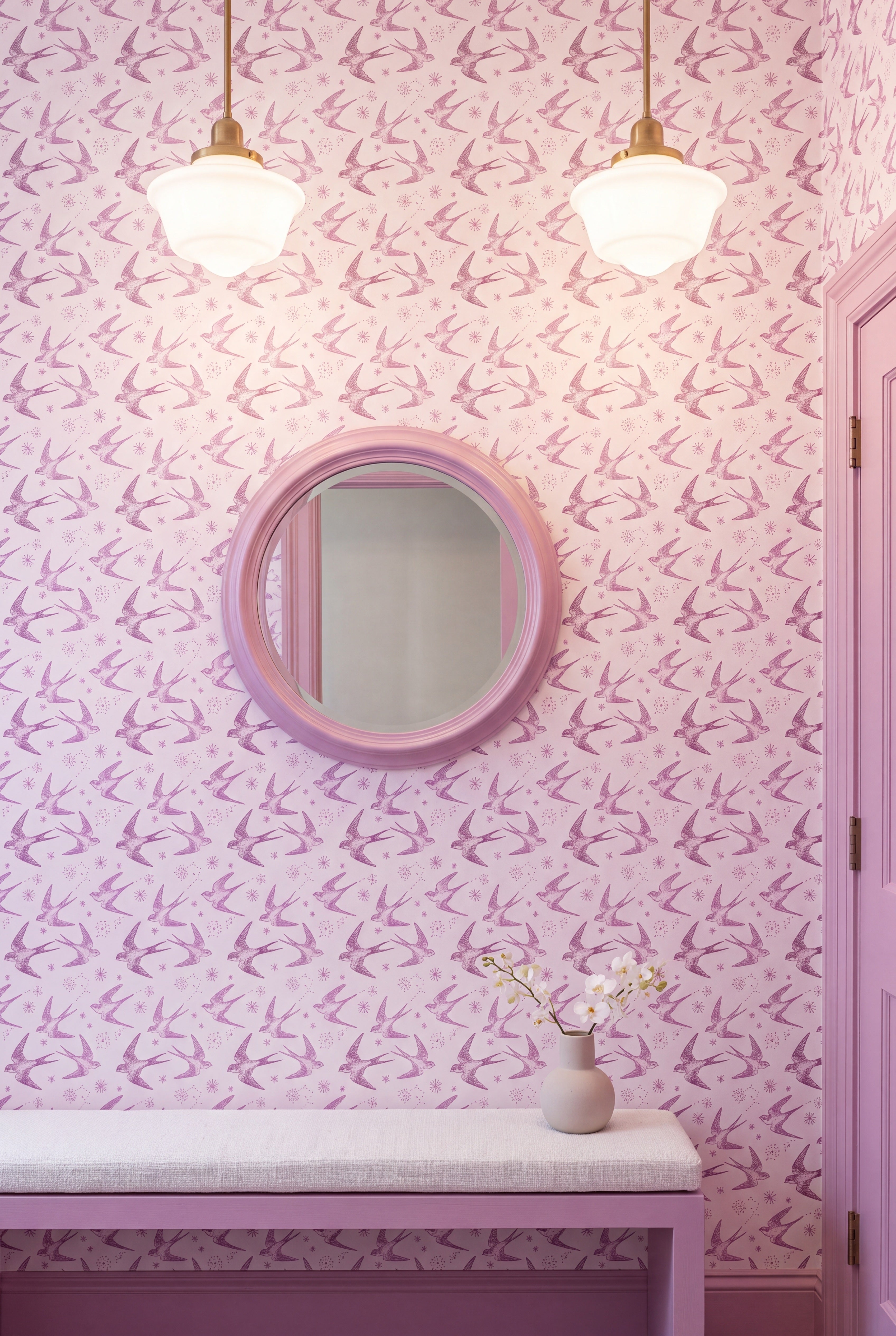 Pink swallows and starbursts on a warm white wallpaper covering an accent wall.