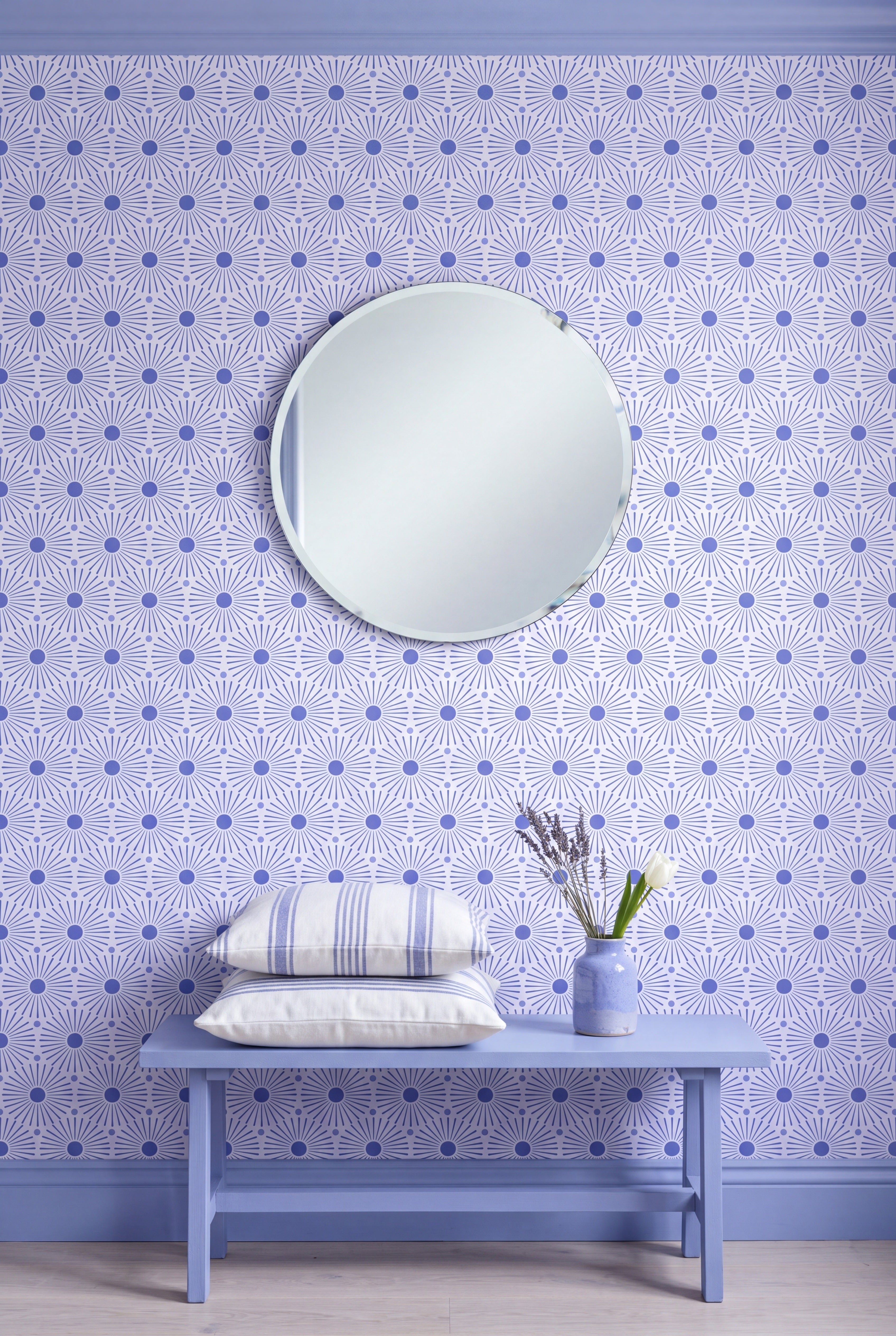 Periwinkle blue starbursts on a soft lilac wallpaper covering an accent wall.