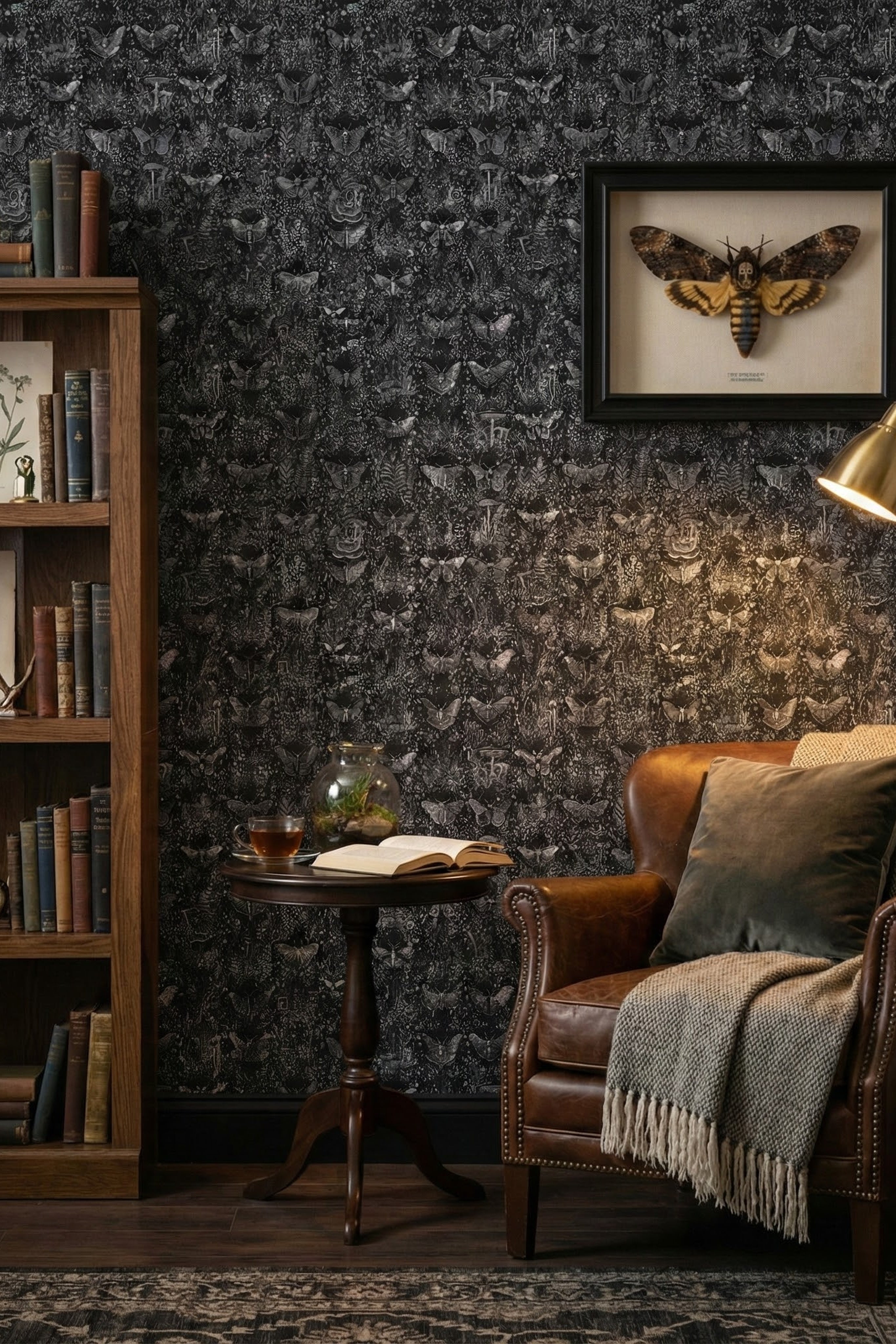 Black-and-white moths and ferns on charcoal wallpaper in a reading corner.