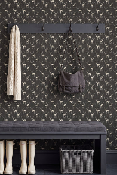 Stags in sunglasses on deep military-green wallpaper on an accent wall.