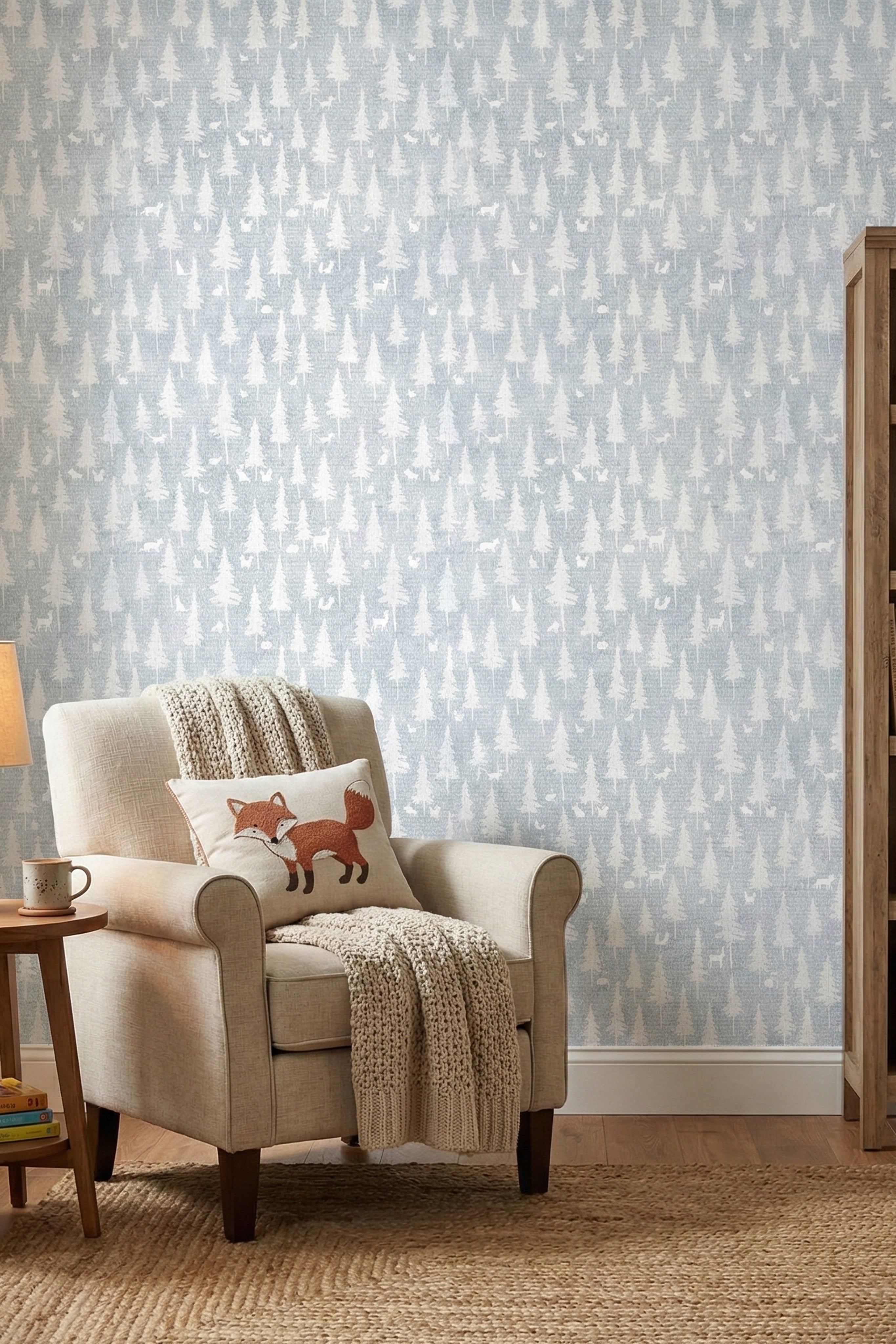 Fox and deer silhouettes on soft blue woodland wallpaper in a reading corner.