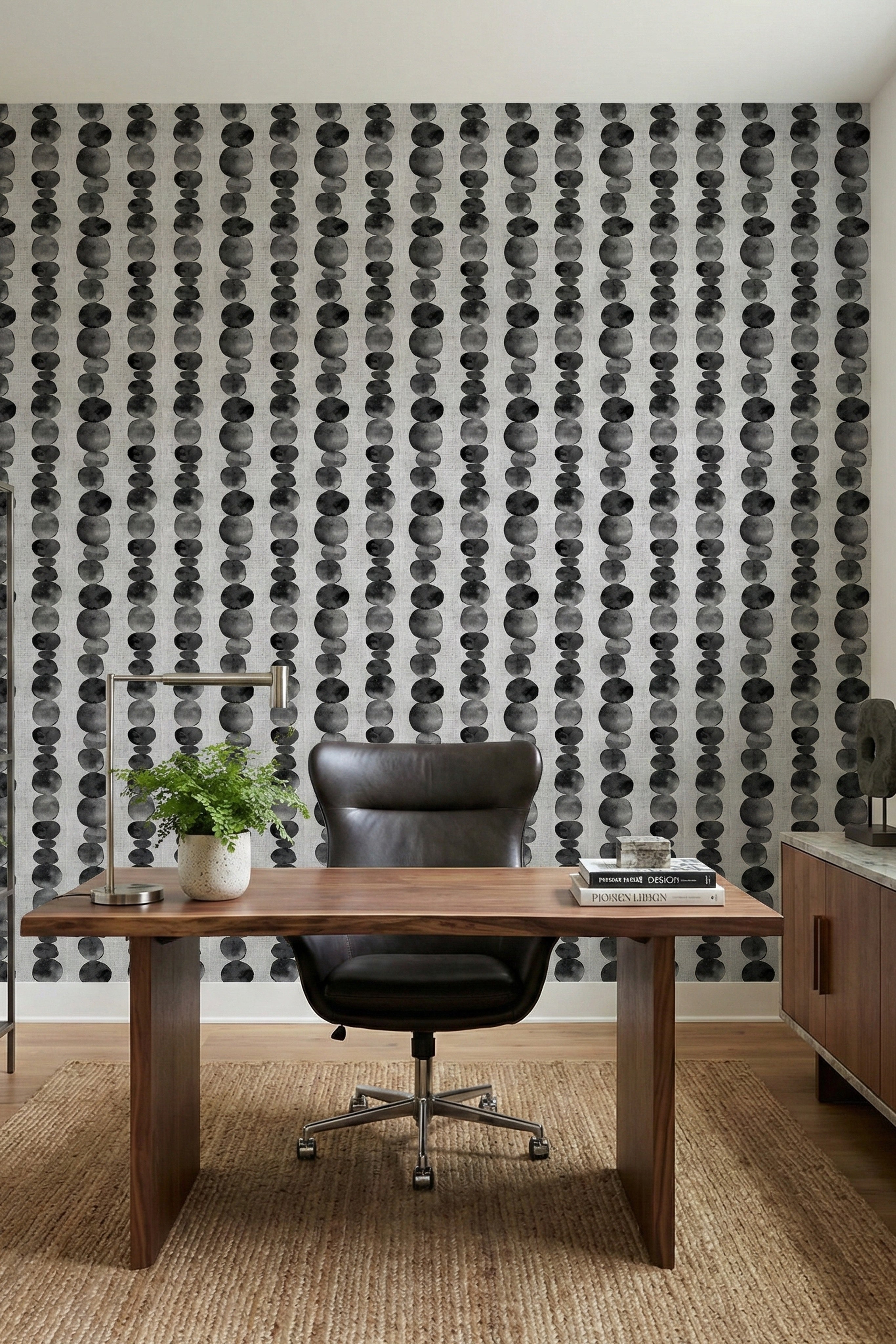 Rows of black and grey watercolor circles on wallpaper in a home office.