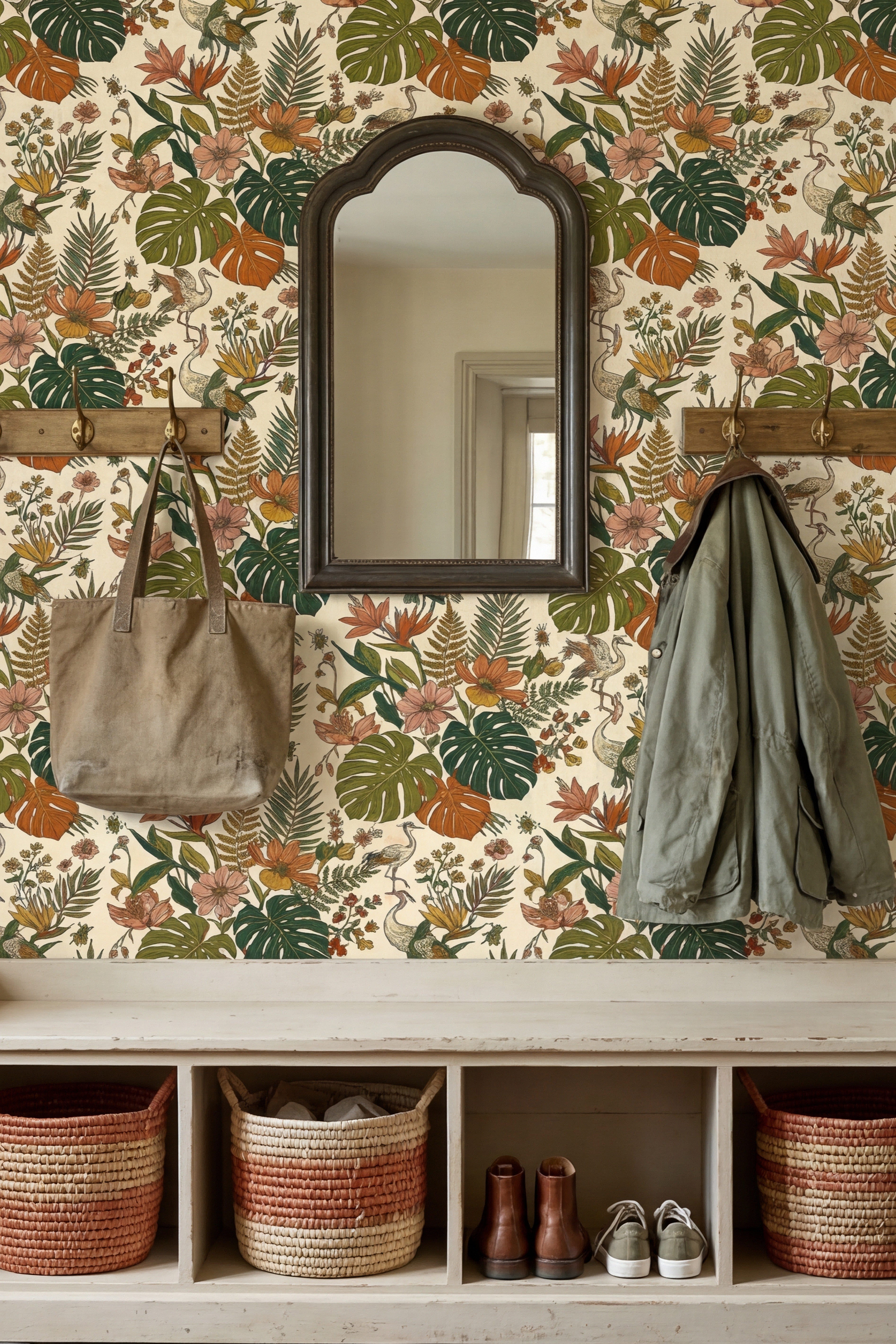 Saturated green monstera leaves and bright florals on tropical wallpaper in a mudroom.