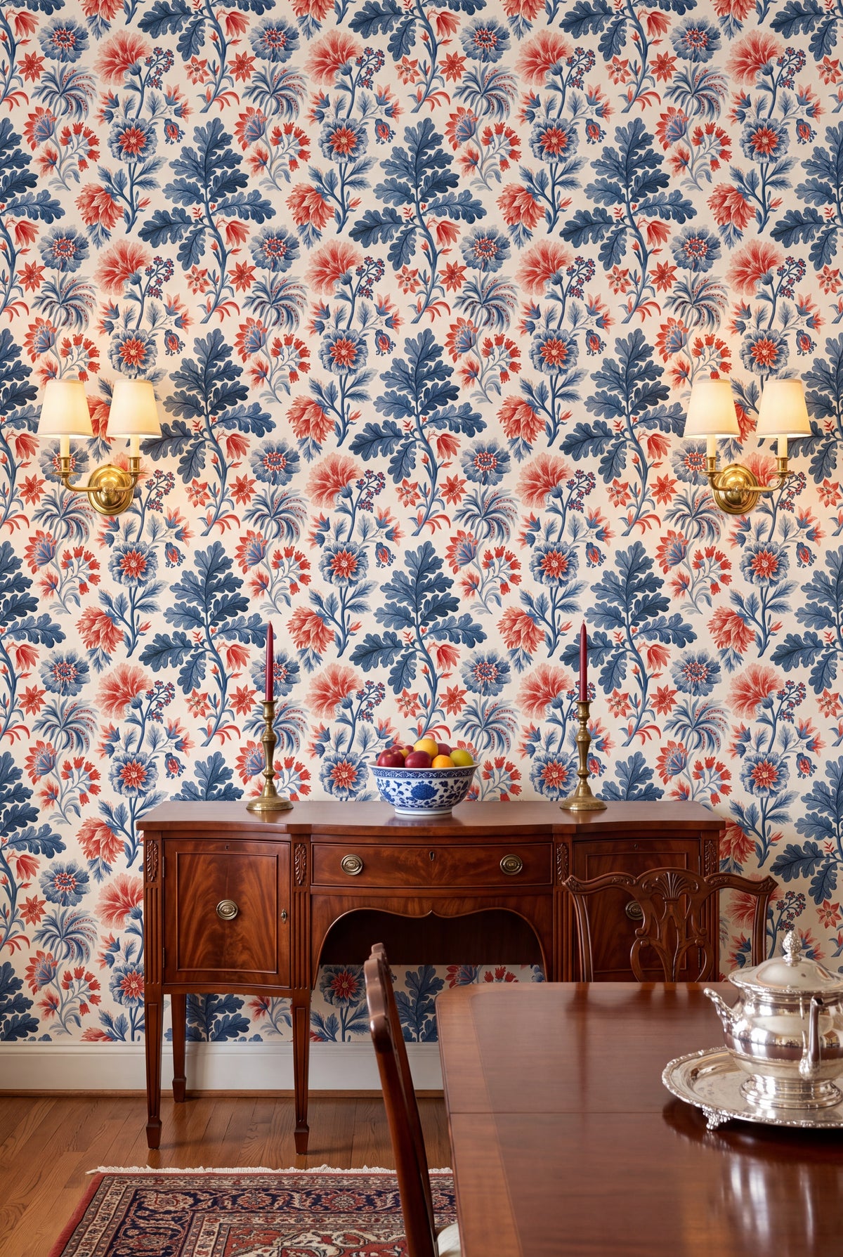 Blue and red Jacobean florals with oak leaf fronds on cream wallpaper in a dining room.