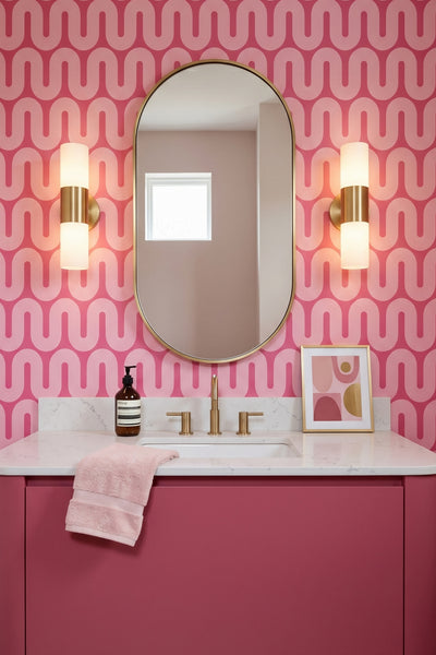 A soft pink squiggle winding across a raspberry wallpaper in a powder room.