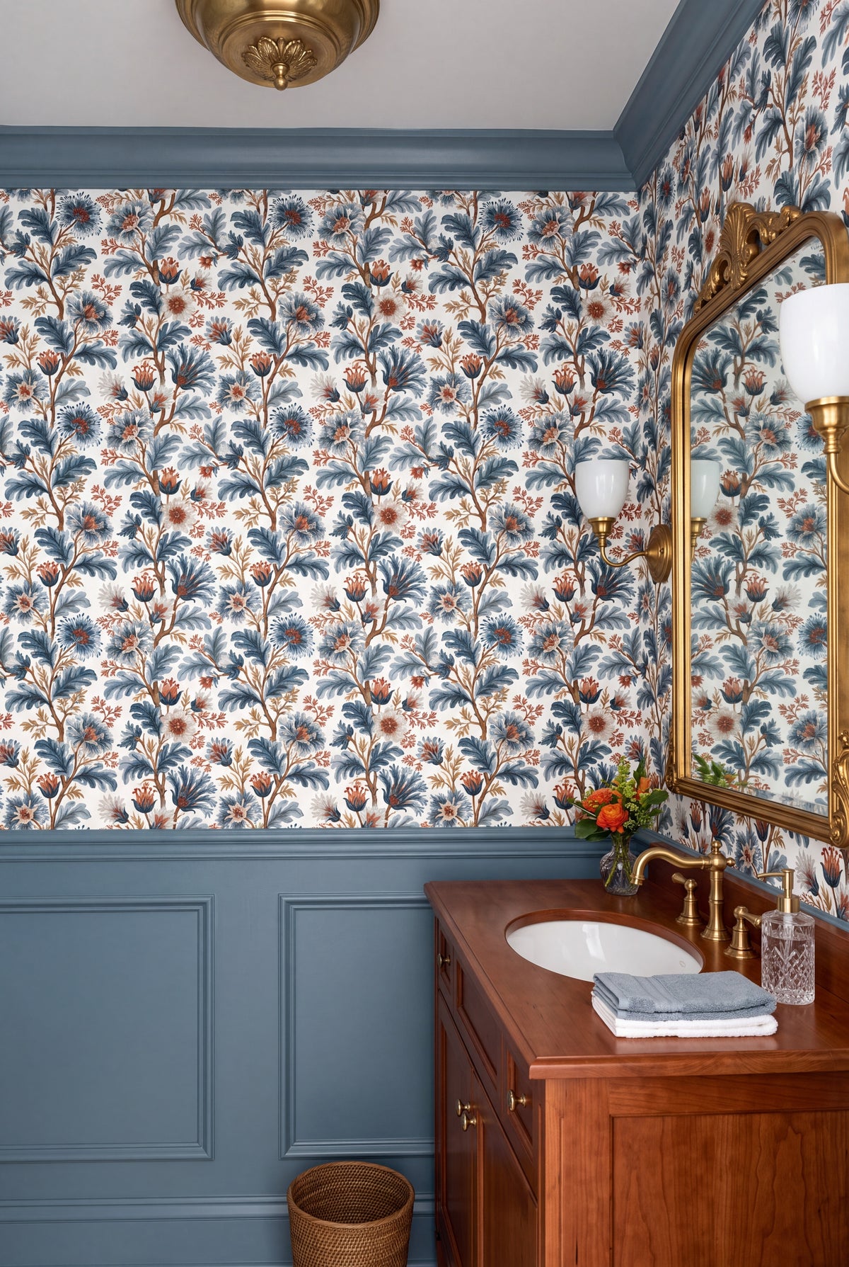 Blue grey florals climbing slender branches on white wallpaper in a powder room.